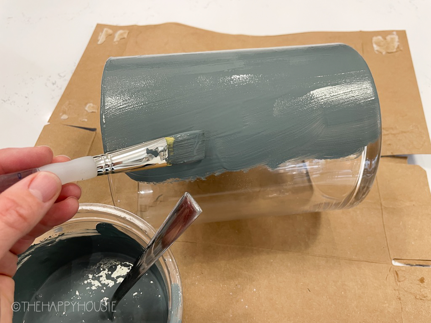 Applying the paint to the glass vase.