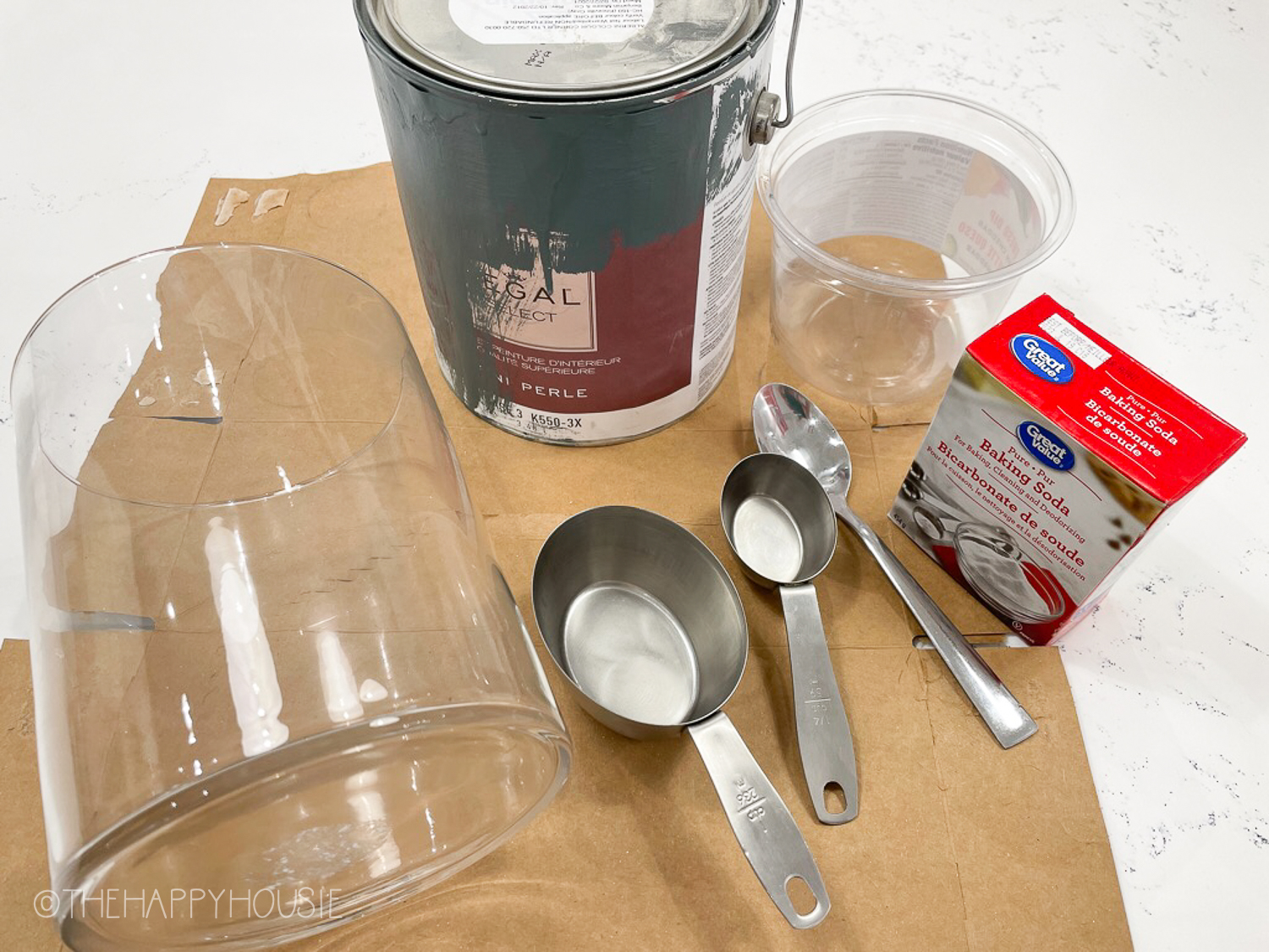 Baking soda is beside a can of paint.