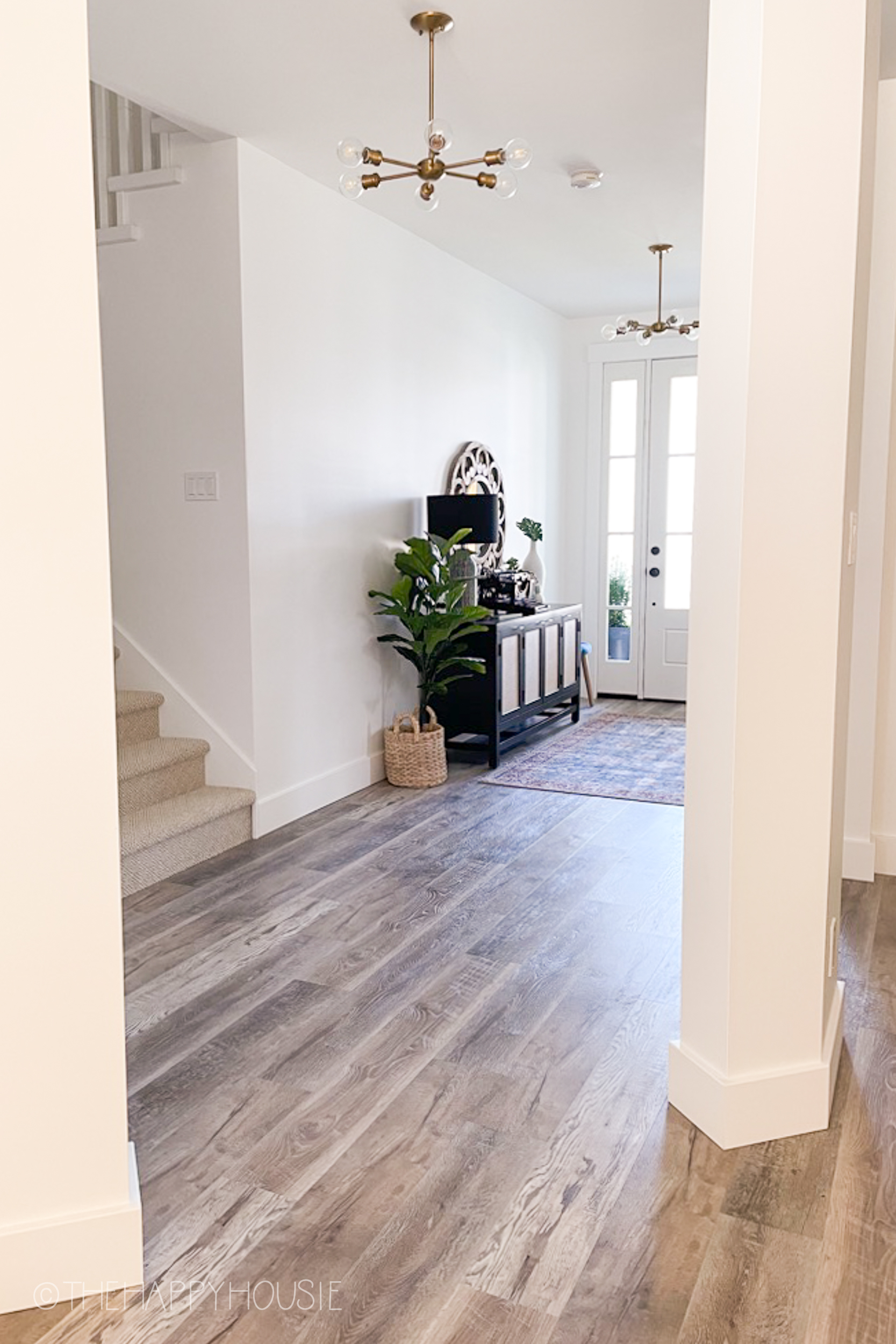 A wide entry foyer with vinyl plank flooring.