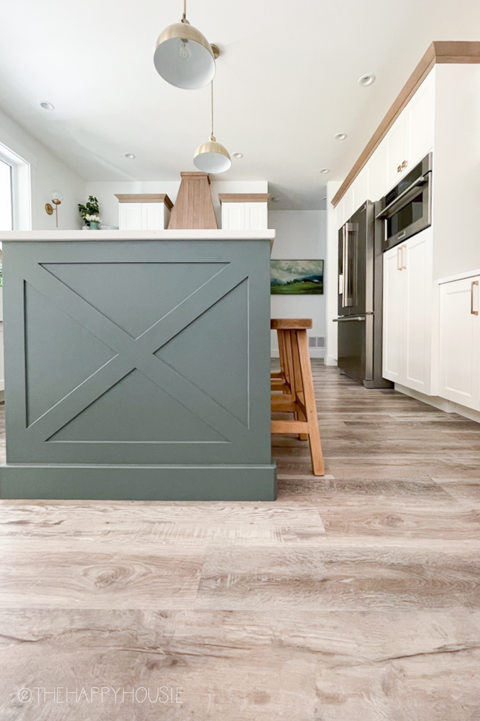 A kitchen island with an X style edge and light and bright vinyl plank kitchen flooring