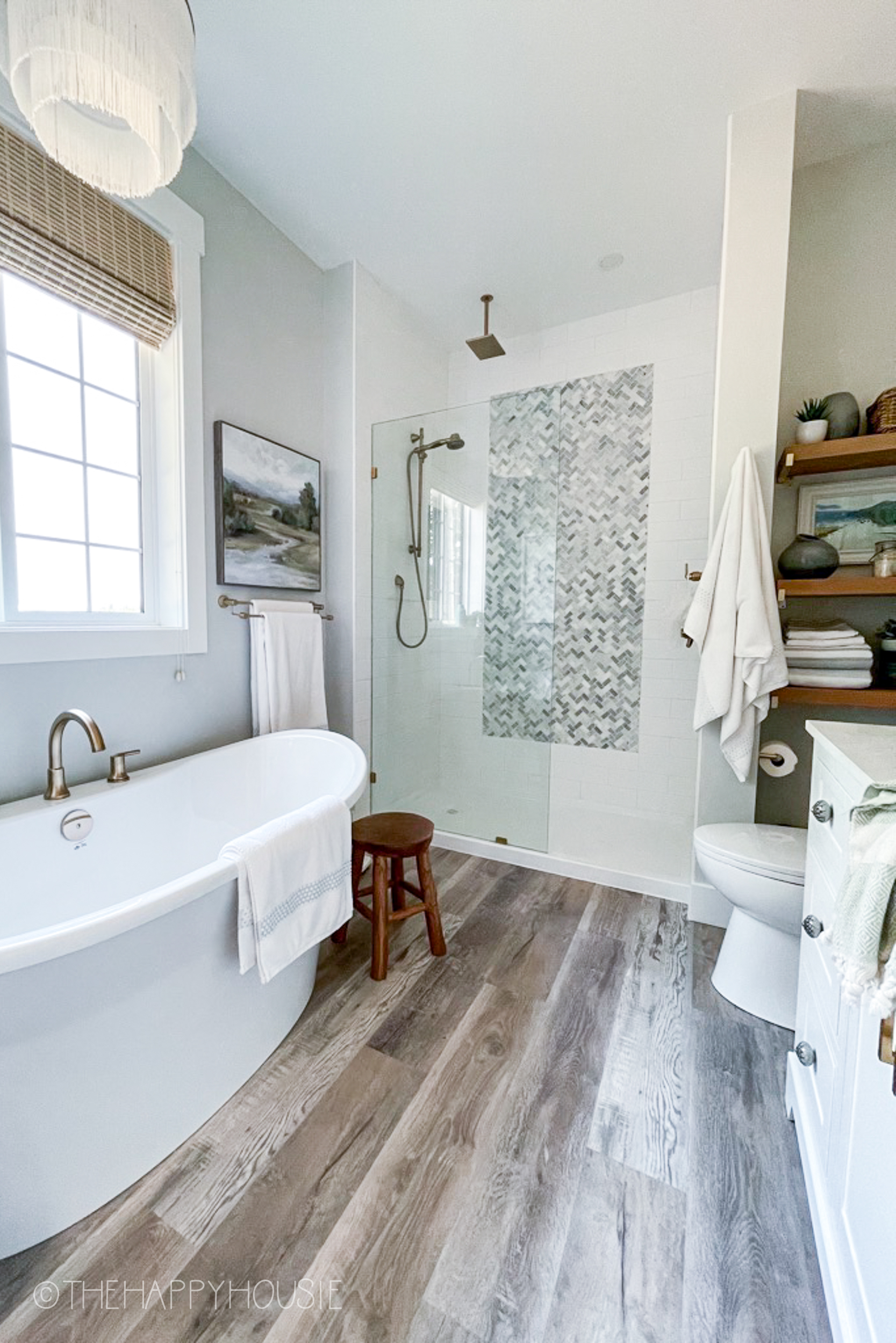 A fresh modern bathroom with a separate tub and shower and vinyl plank floors
