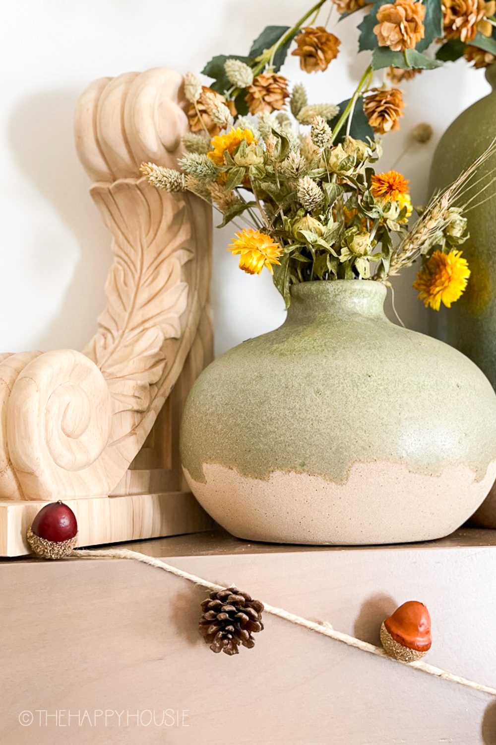 A soft green and neutral pottery vase.