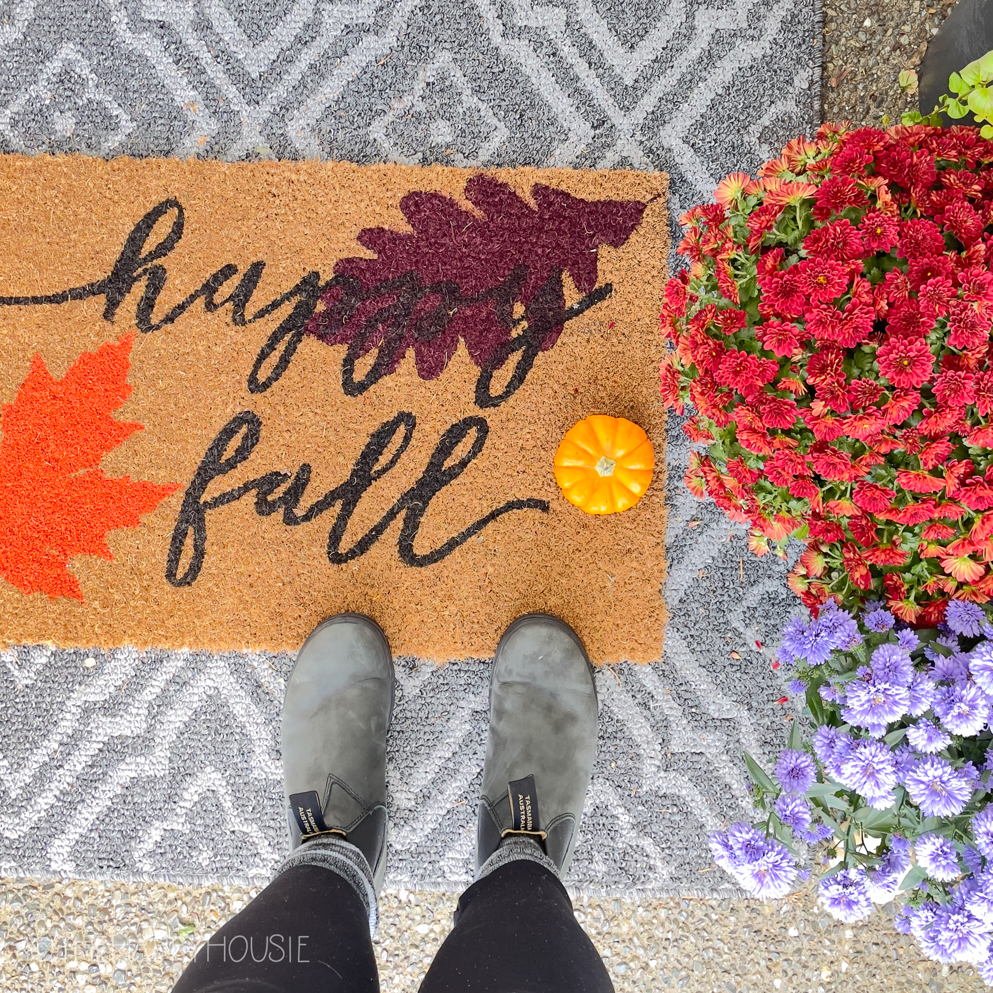 A front door mat that says Happy Fall.