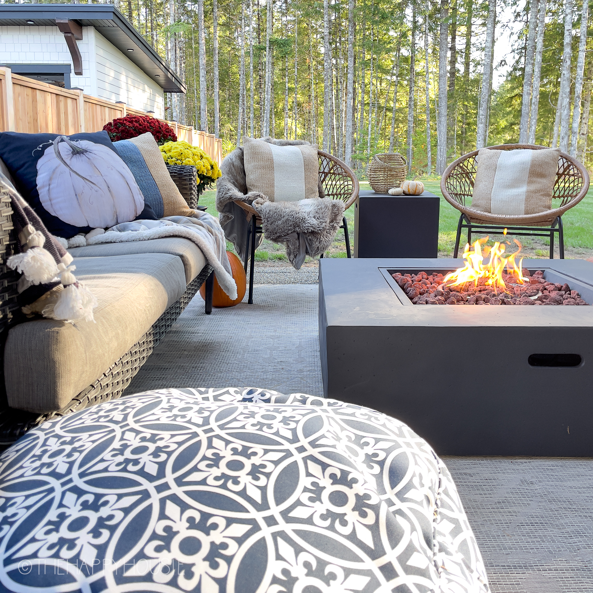 A small couch is by the outdoor fireplace.
