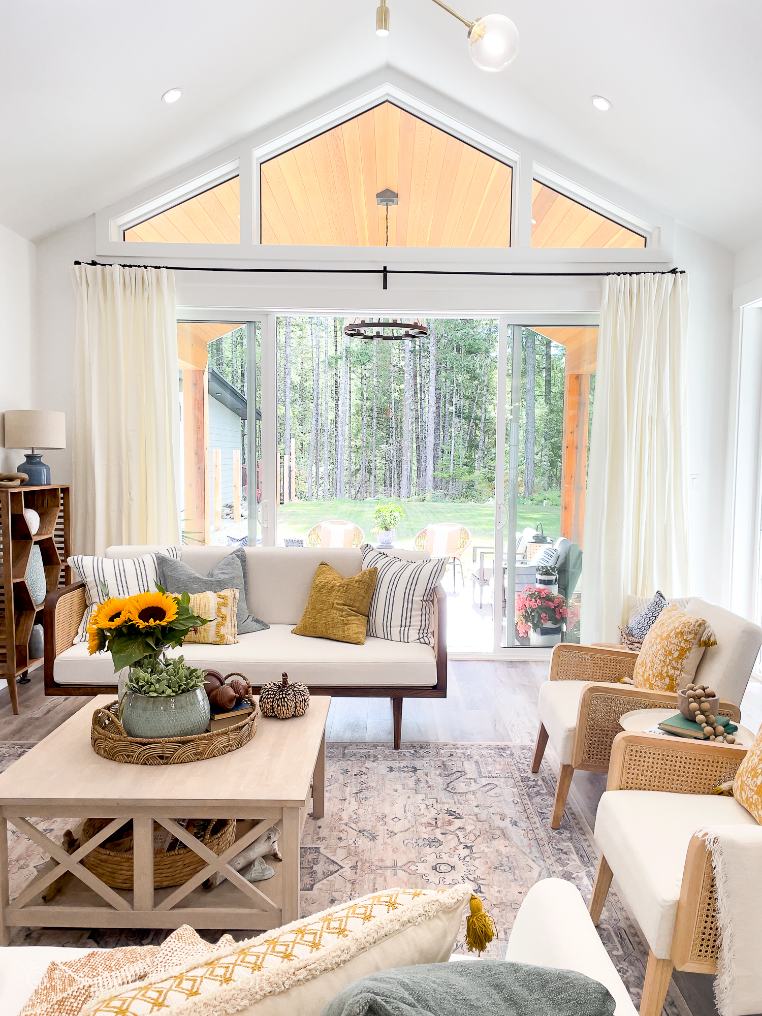 a bright and airy living room featuring vaulted ceilings