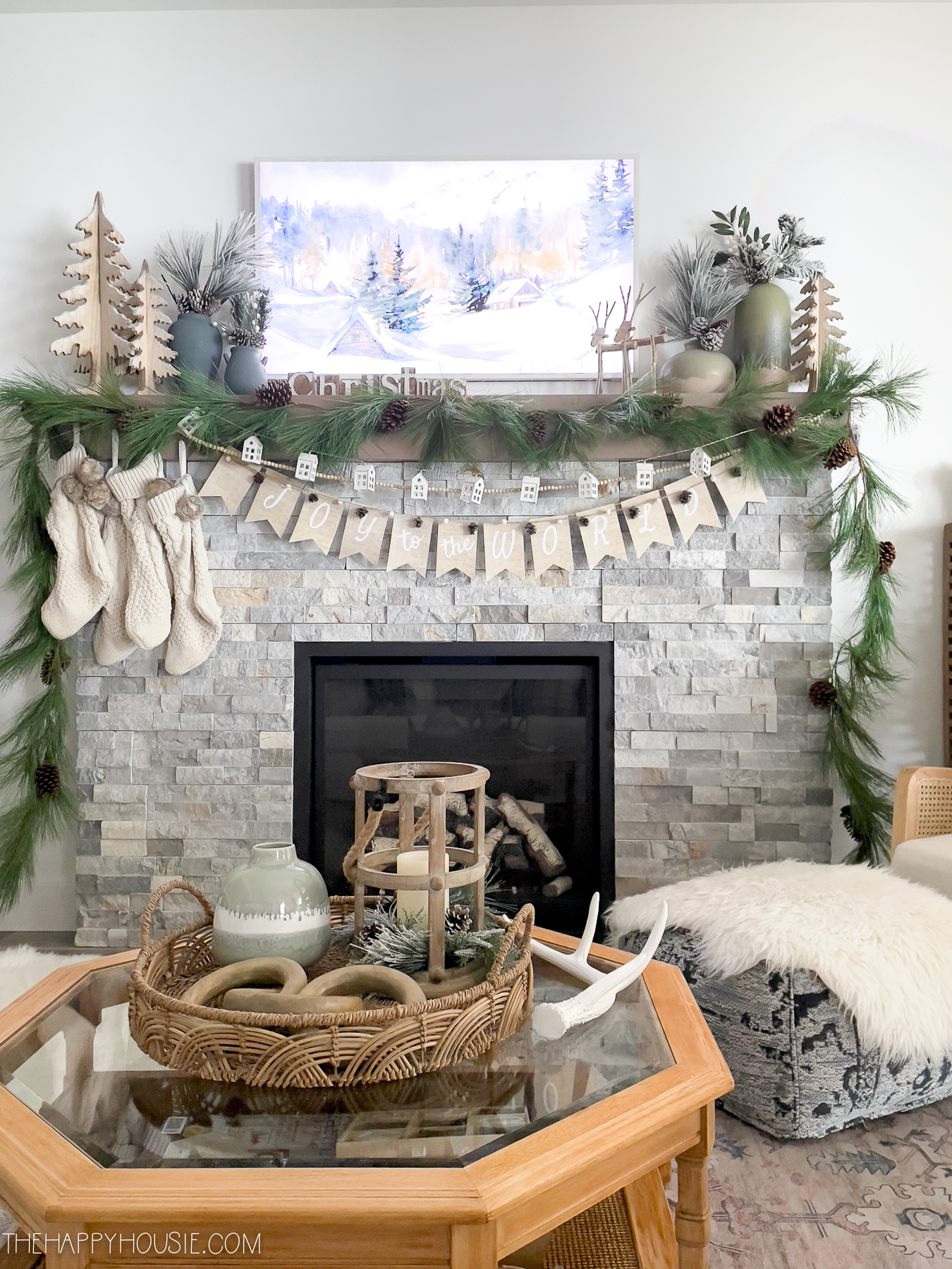 A beautiful vignette on the fireplace mantel includes a picture and an evergreen garland.