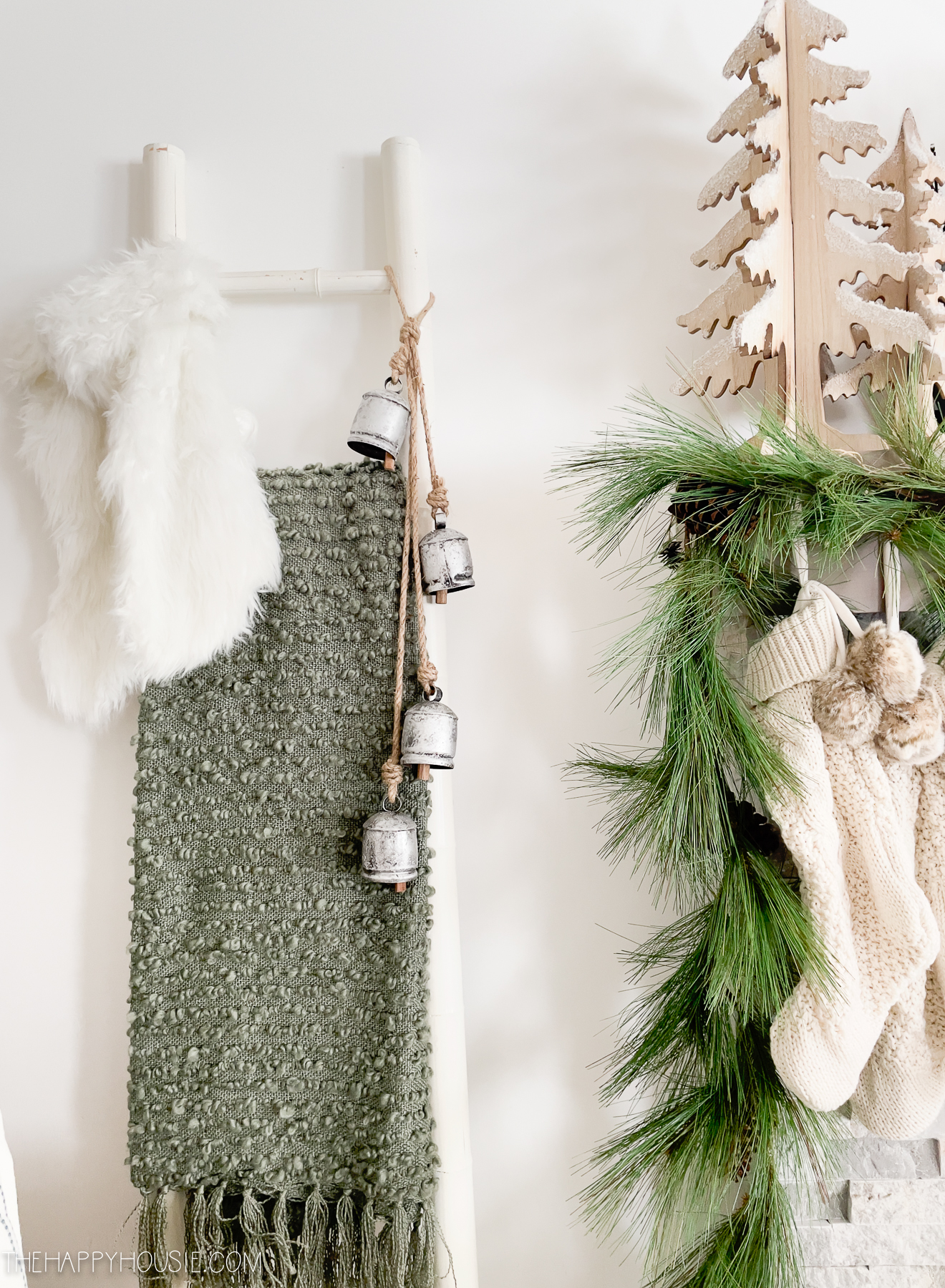 A blanket ladder with a green blanket on it and bells.