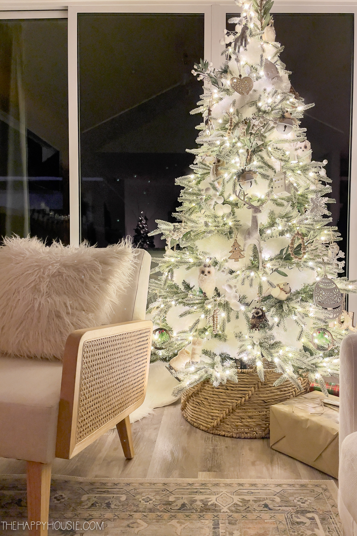 a light and white Christmas tree at night in a living room