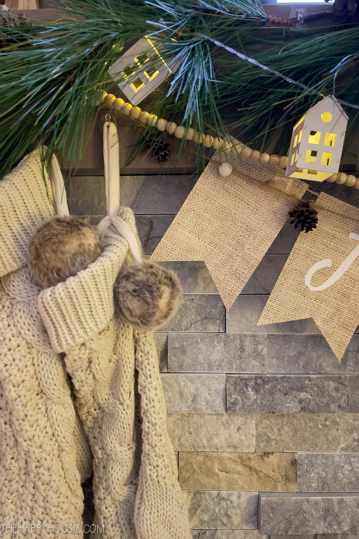cozy wooden stockings with fur pom poms and Scandi style house lights