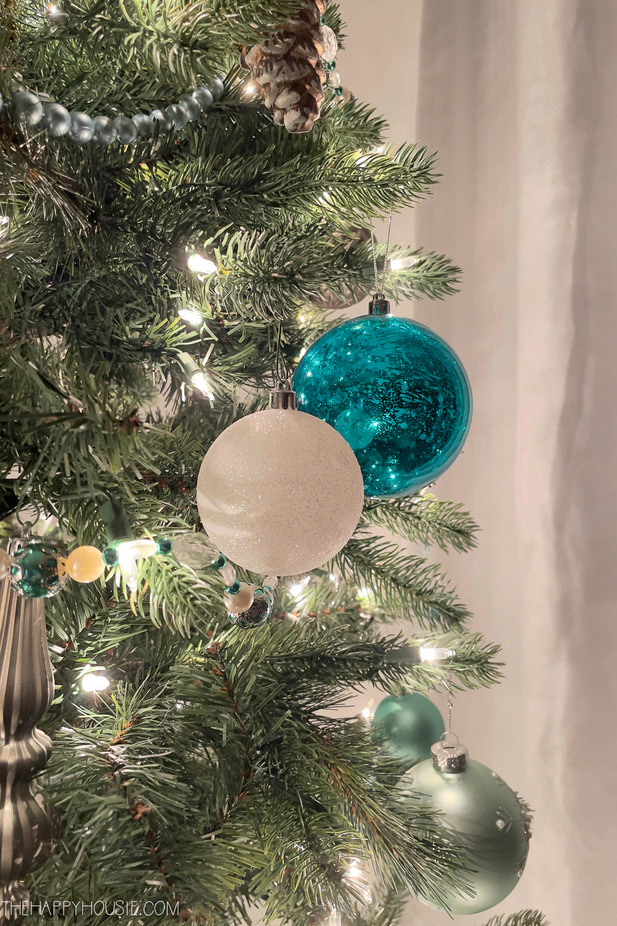 teal and white ornaments on a Christmas tree