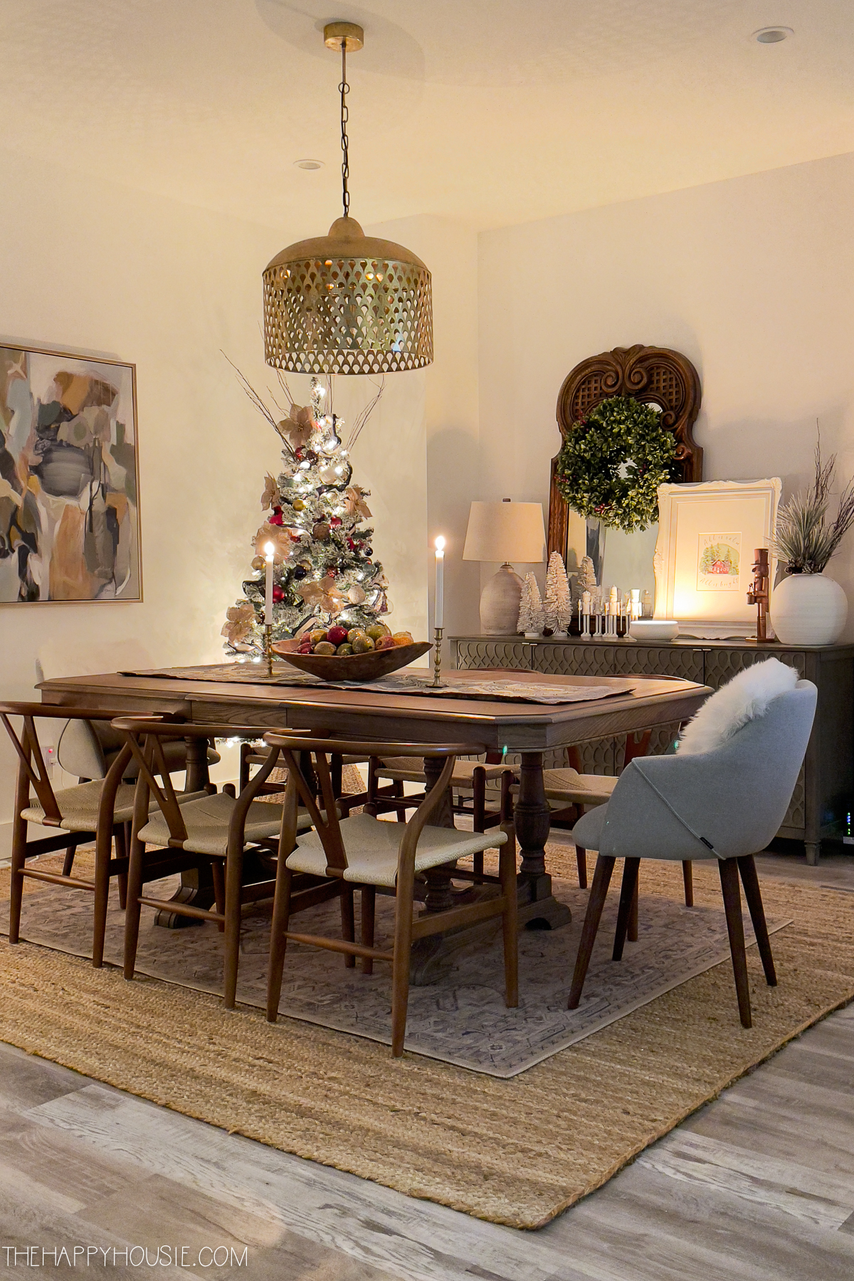 a cozy candlelit dining room with two Christmas trees