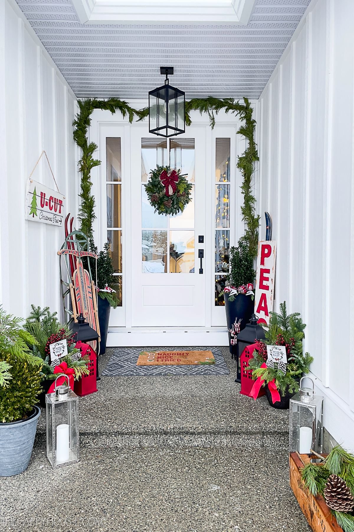 A modern farmhouse style front porch decorated for Christmas.