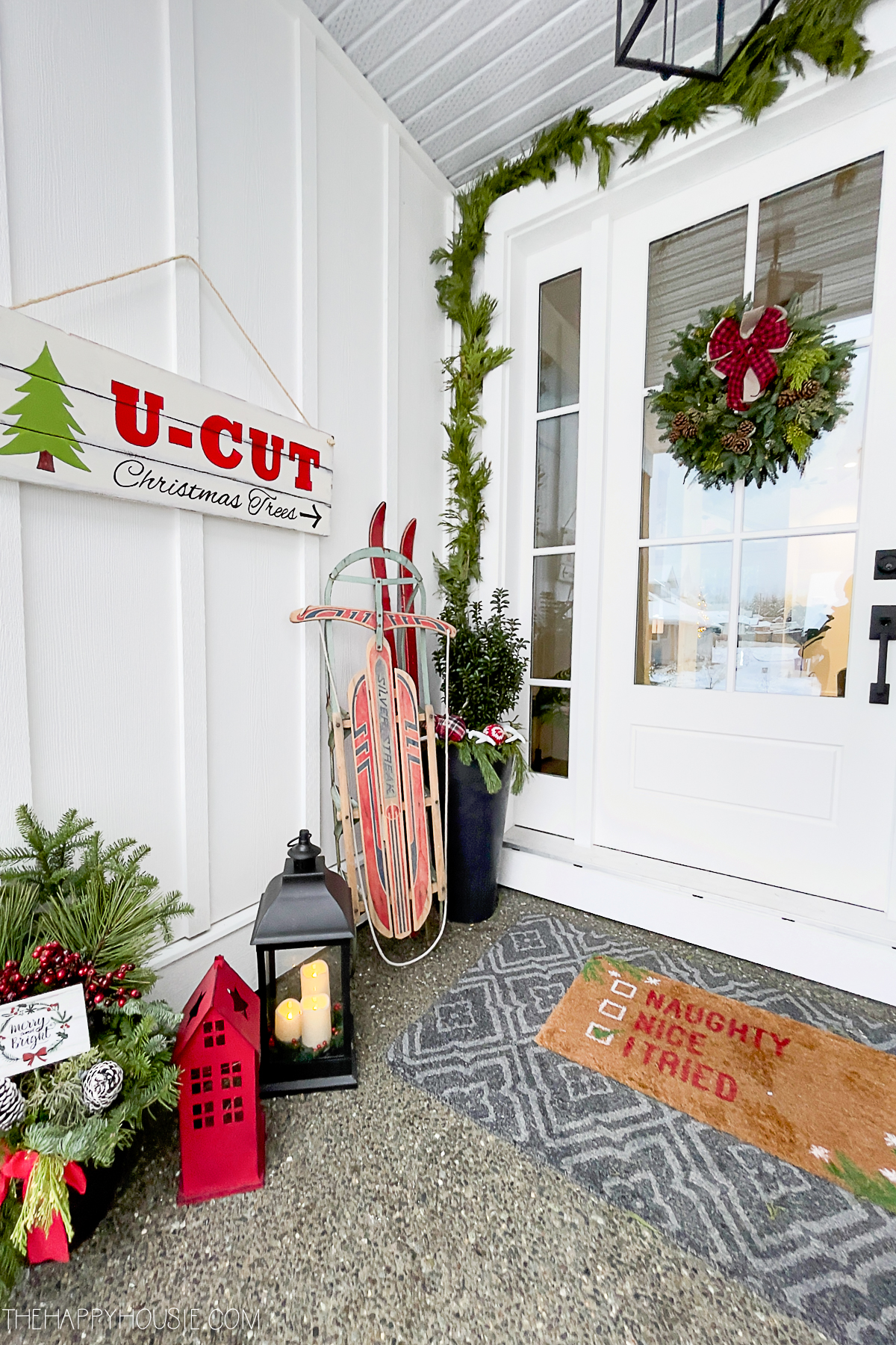 a DIY U-Cut Christmas Tree sign displayed on a front porch
