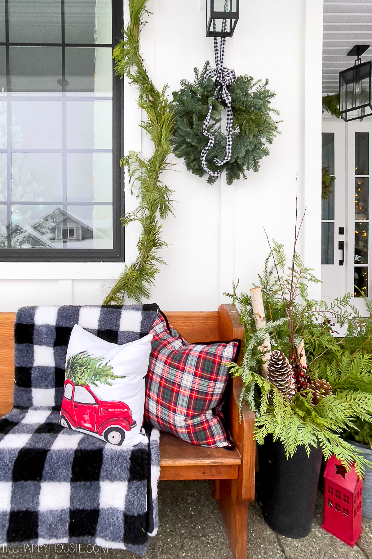 Large pots stuffed with Christmas Greenery on a modern farmhouse front porch