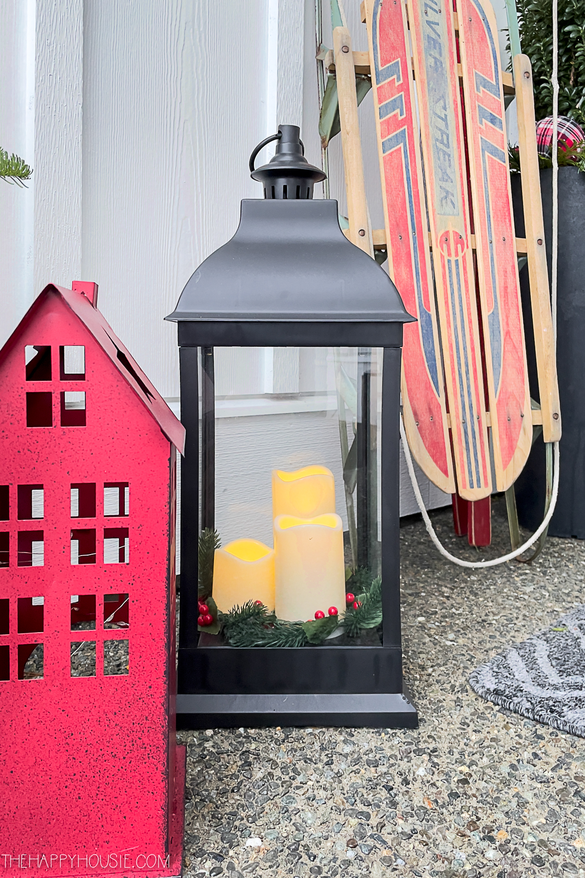 softly glowing black candle lanterns on a Christmas porch