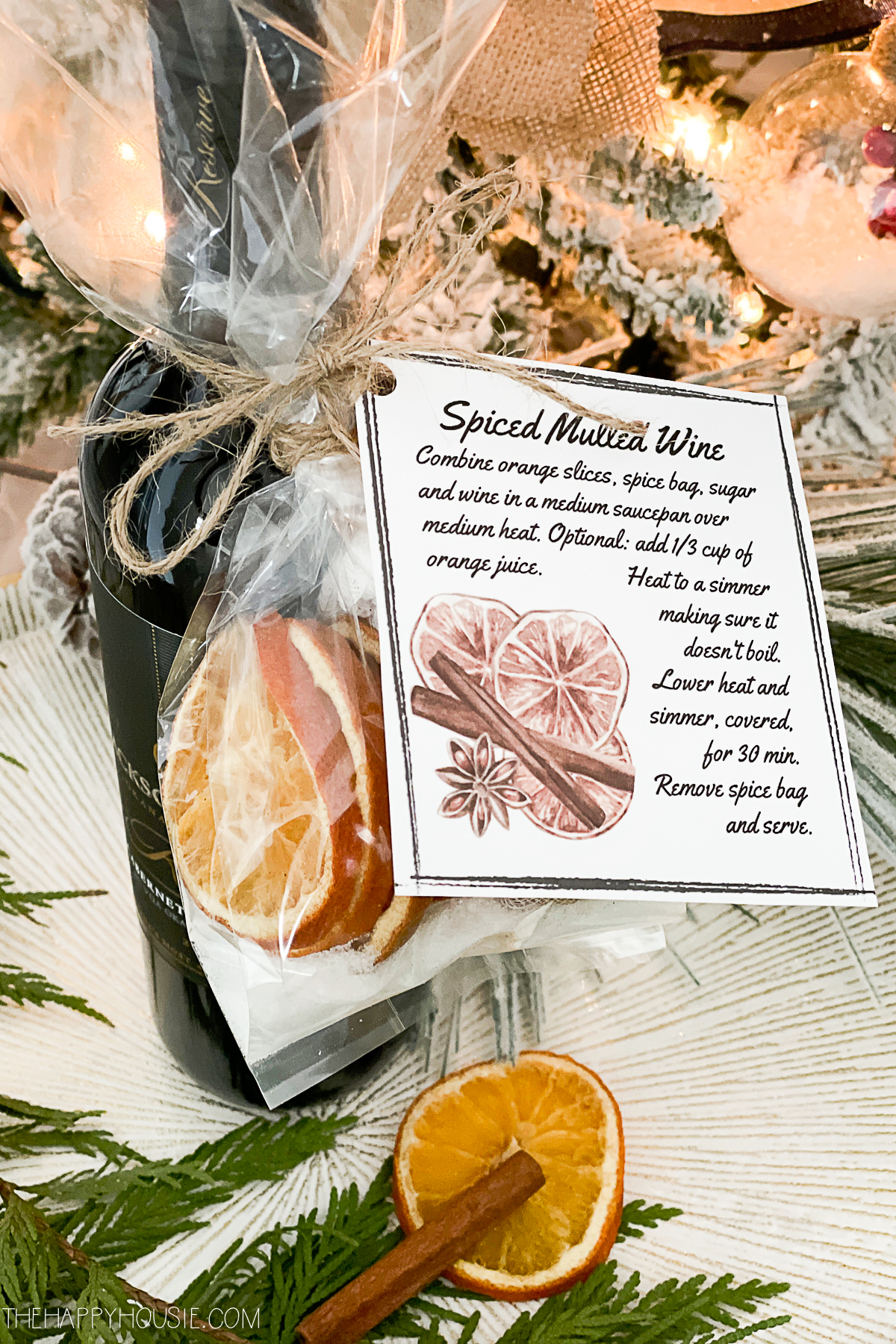 red wine with instructions and mulling spices attached to it as a holiday gift idea