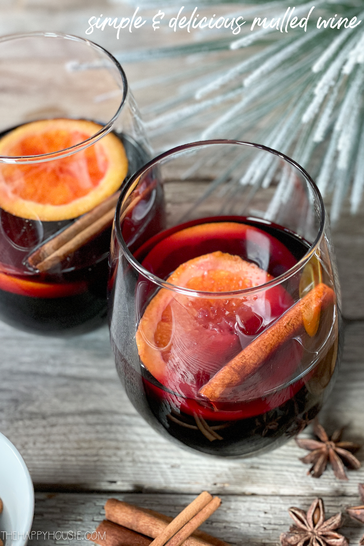 Two glasses of spiced mulled wine with orange slices and cinnamon sticks