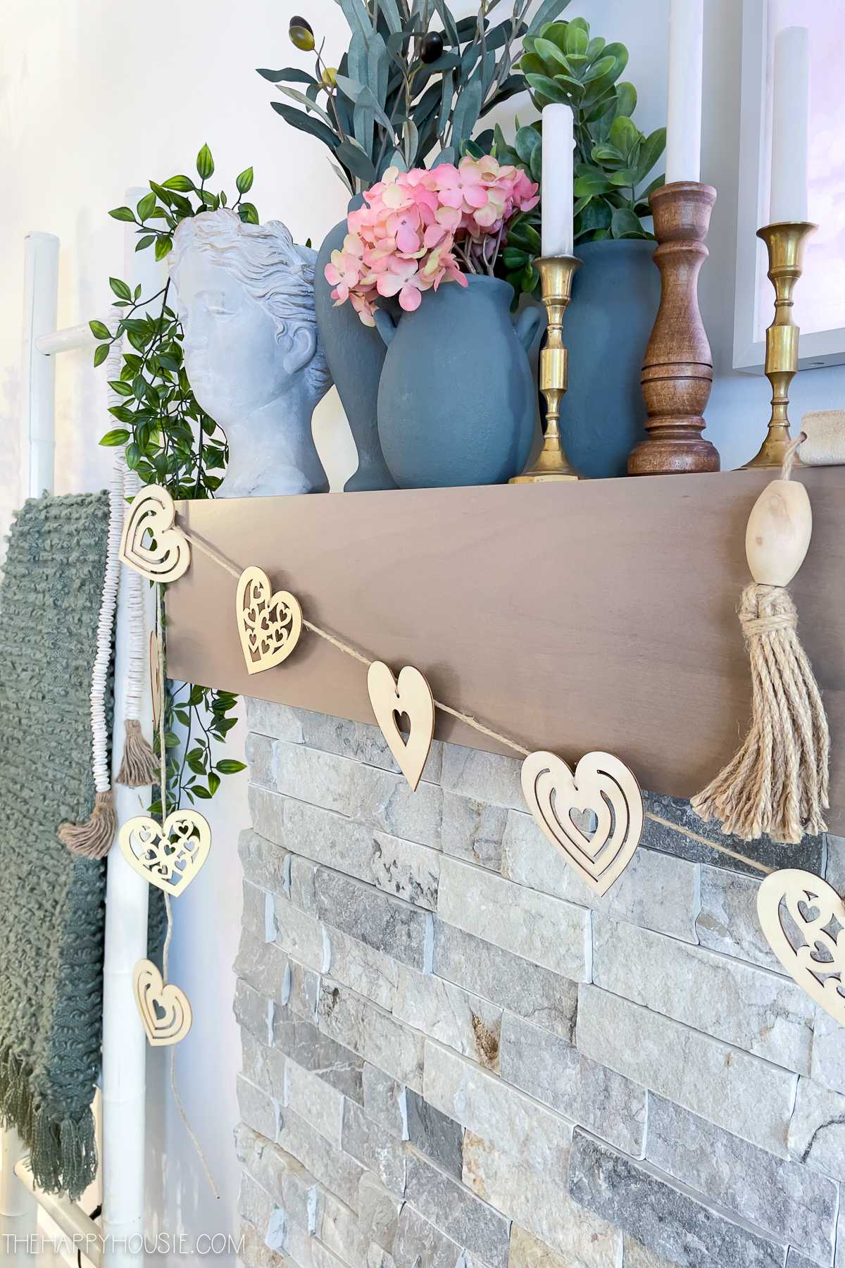 The wooden heart garland on the fireplace.