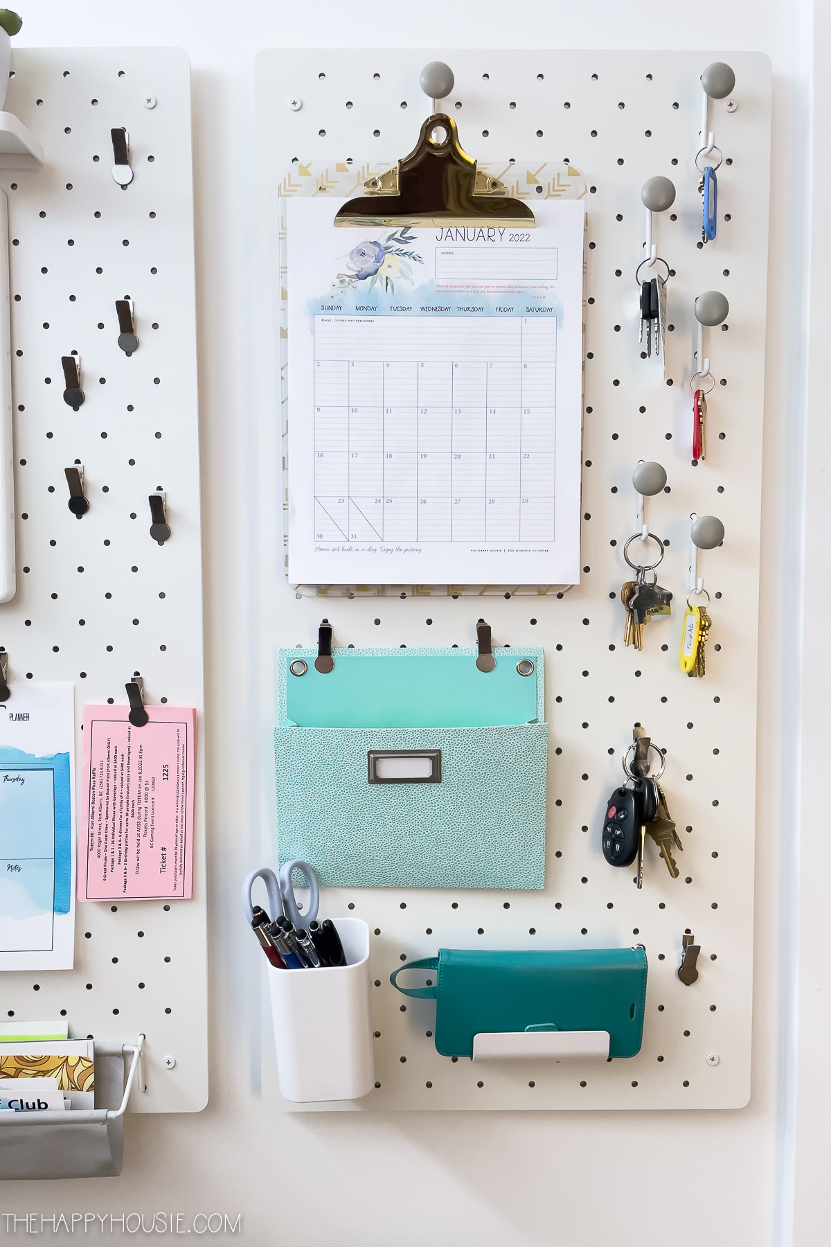 Monthly calendar hung on a clipboard on a pegboard organizer