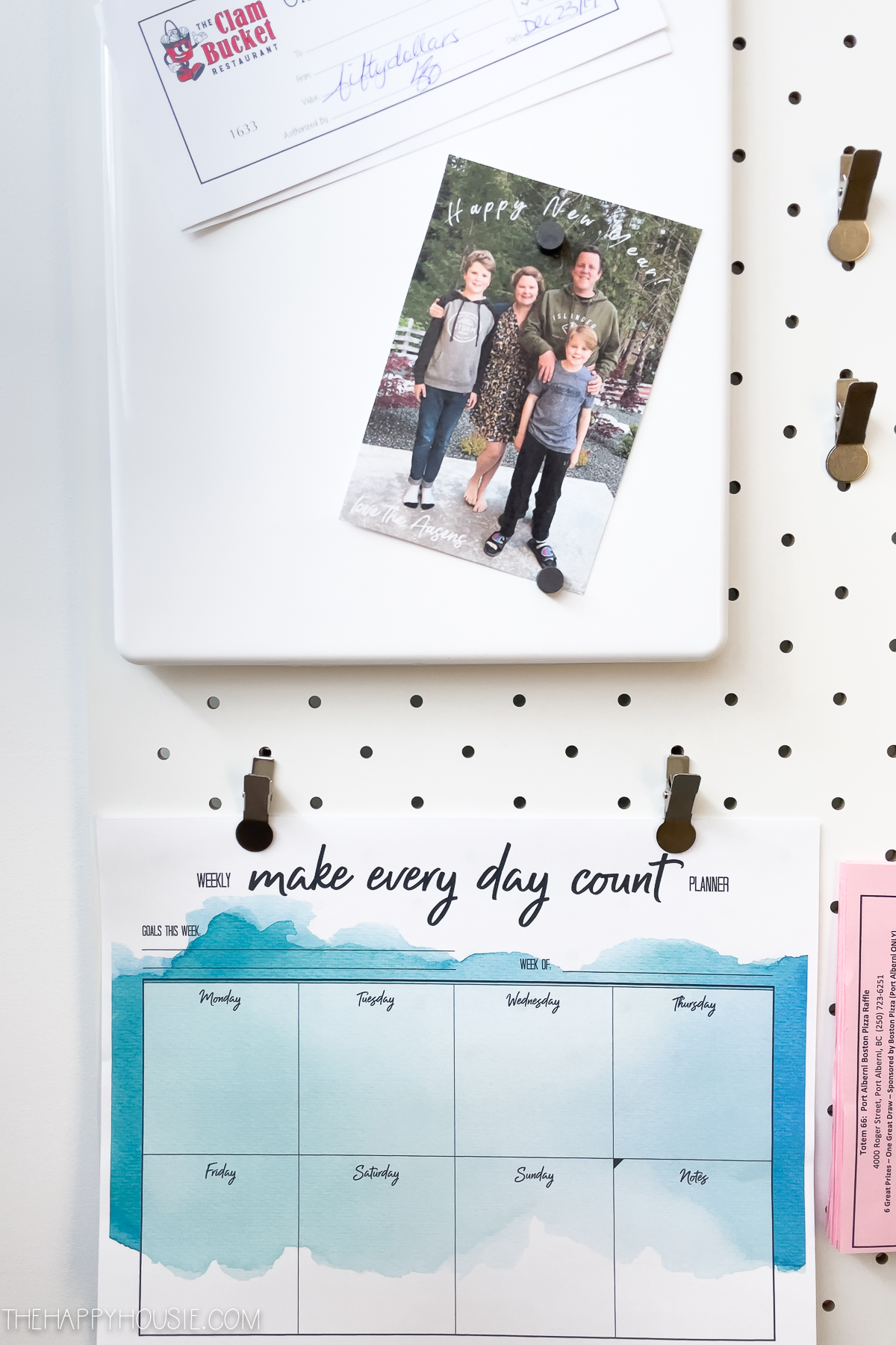 a magnetic memo board and weekly planner displayed on a pegboard organizer