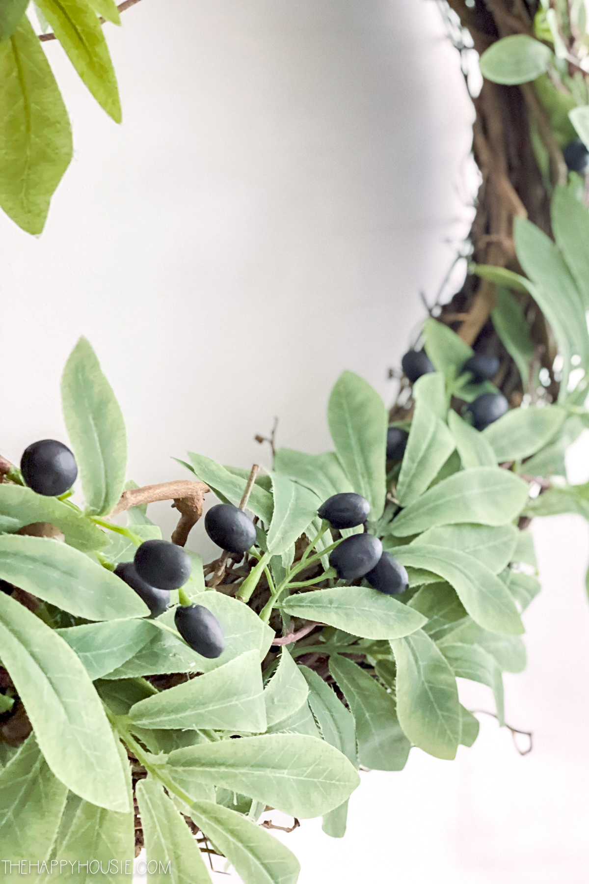The olive wreath with green leaves and black olives.