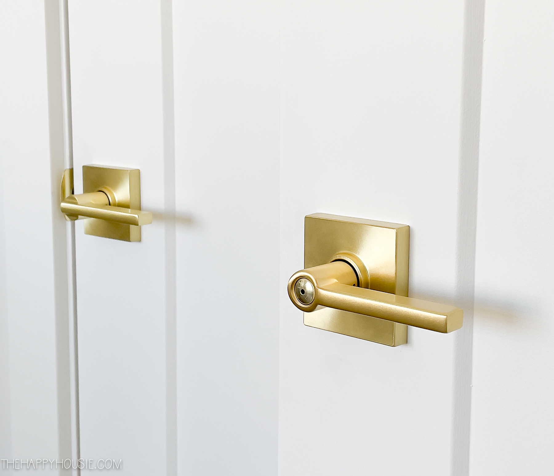 two Schlage Latitude Lever sets in satin brass shown on interior doors