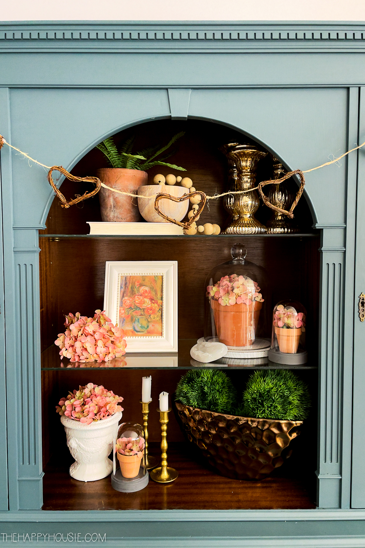 A wooden hutch with classy Valentine's Day decor items.