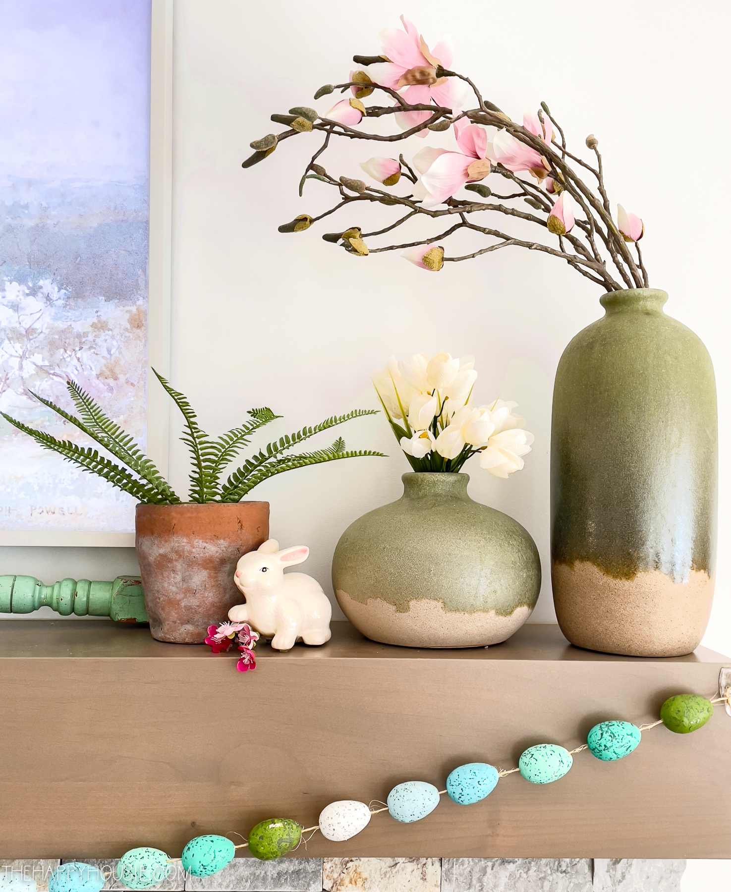 faux spring blossoms displayed on a mantel decorated for spring