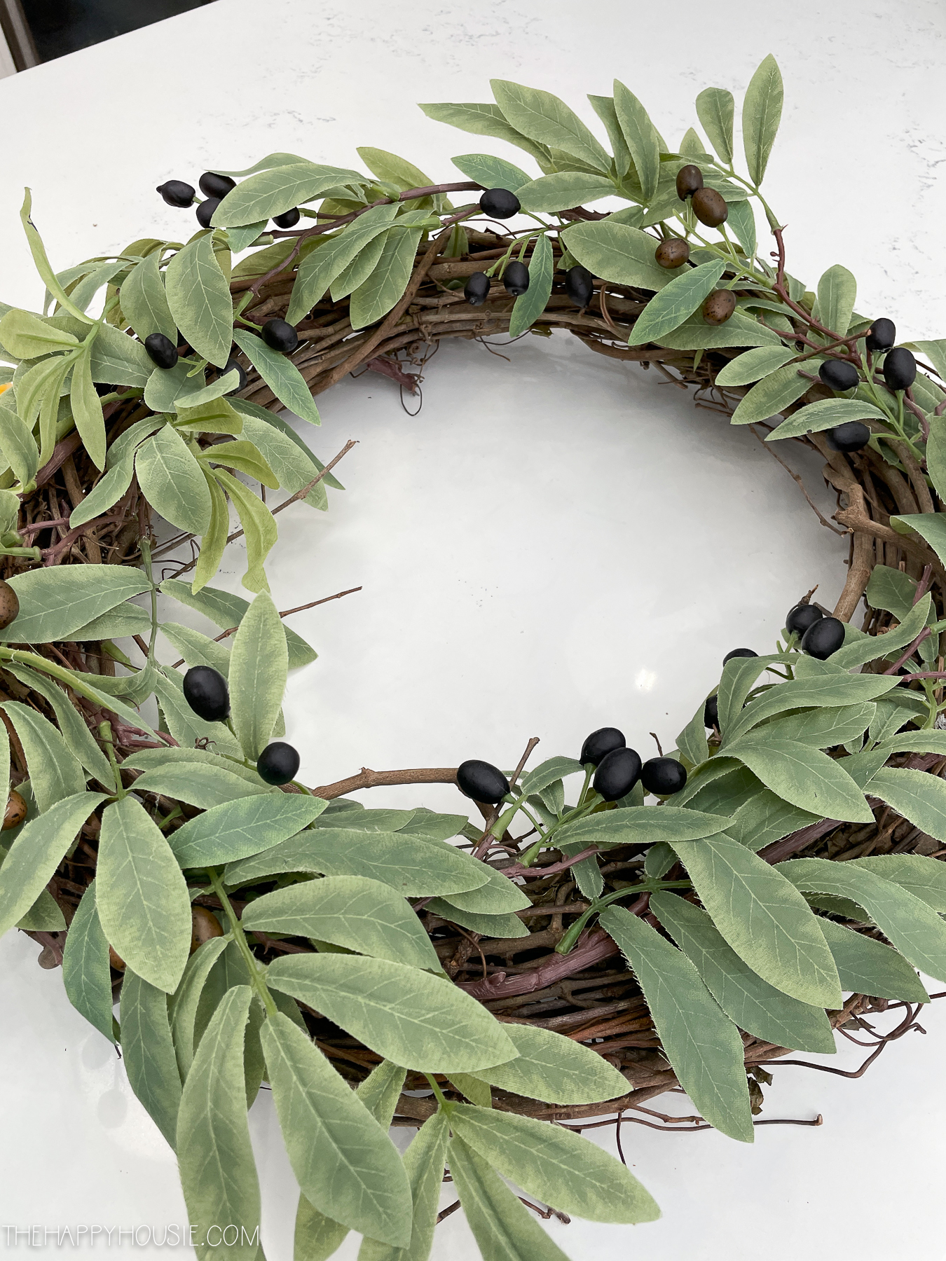 olive branches attached to a grapevine wreath form
