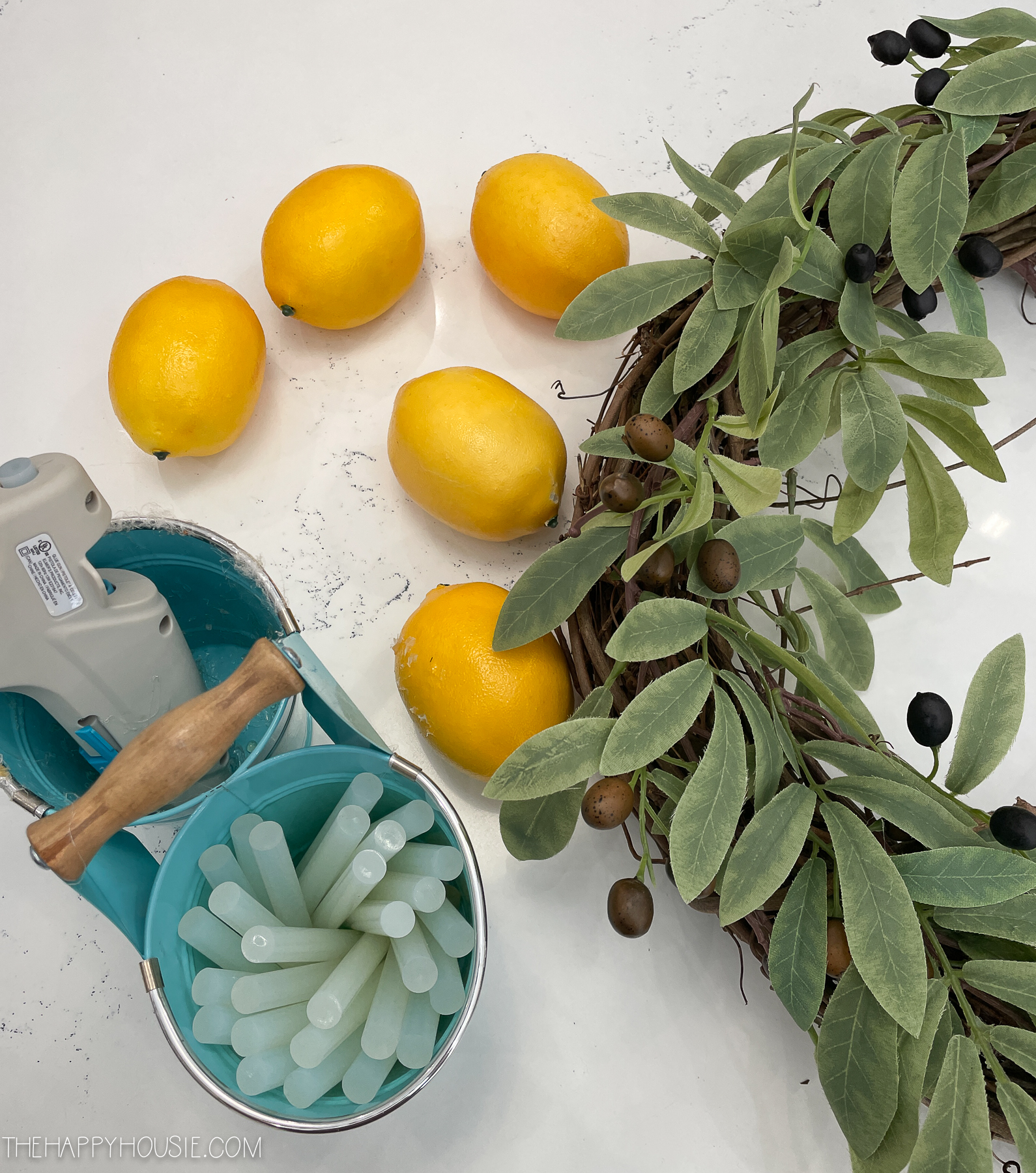 hot glue lemons and olive branches laid out to use to make a wreath