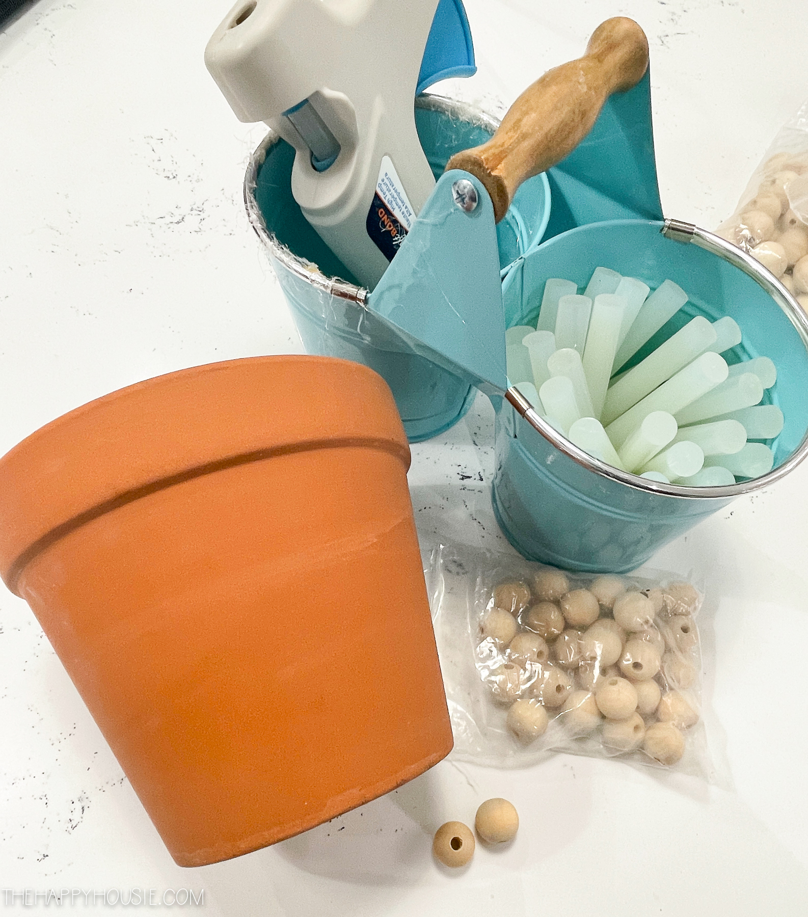 A container for a potted plant, Glue gun and glue sticks.