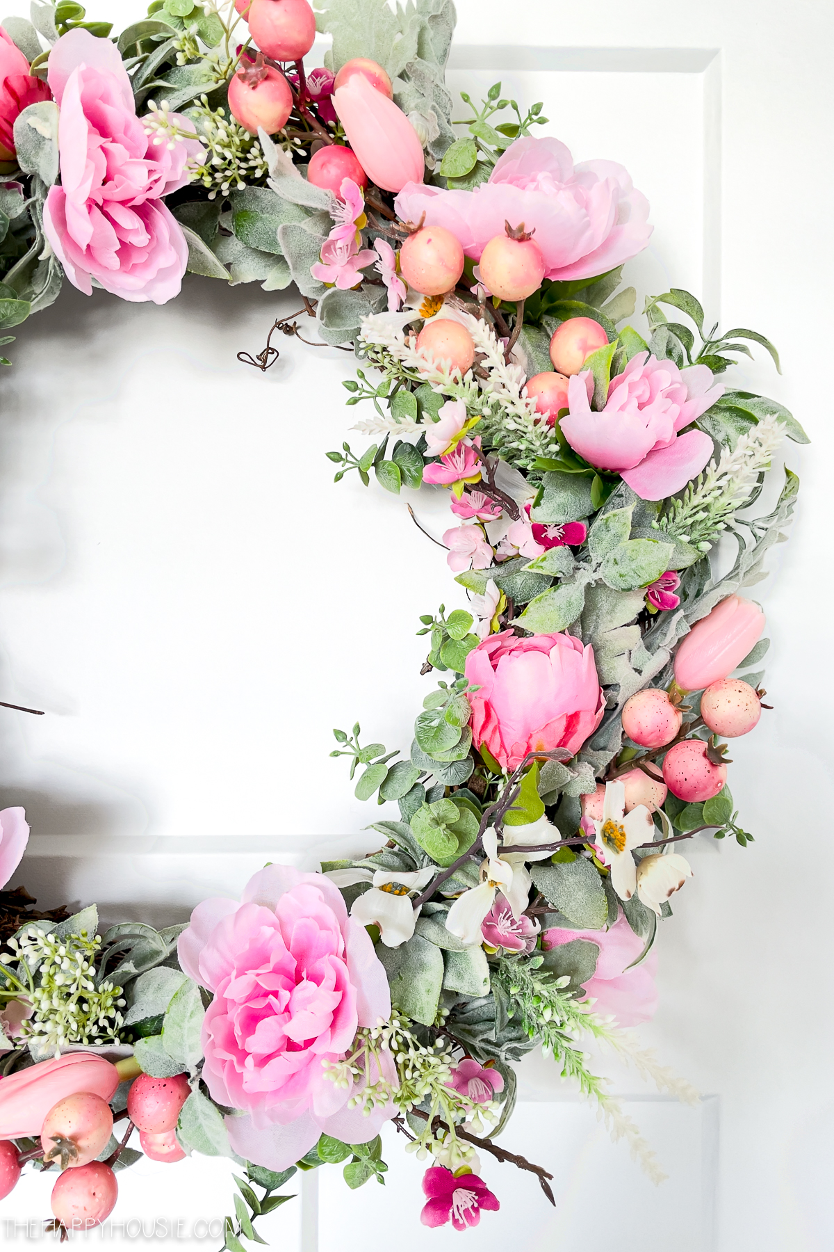 half of a DIY spring wreath featuring pink blossoms 