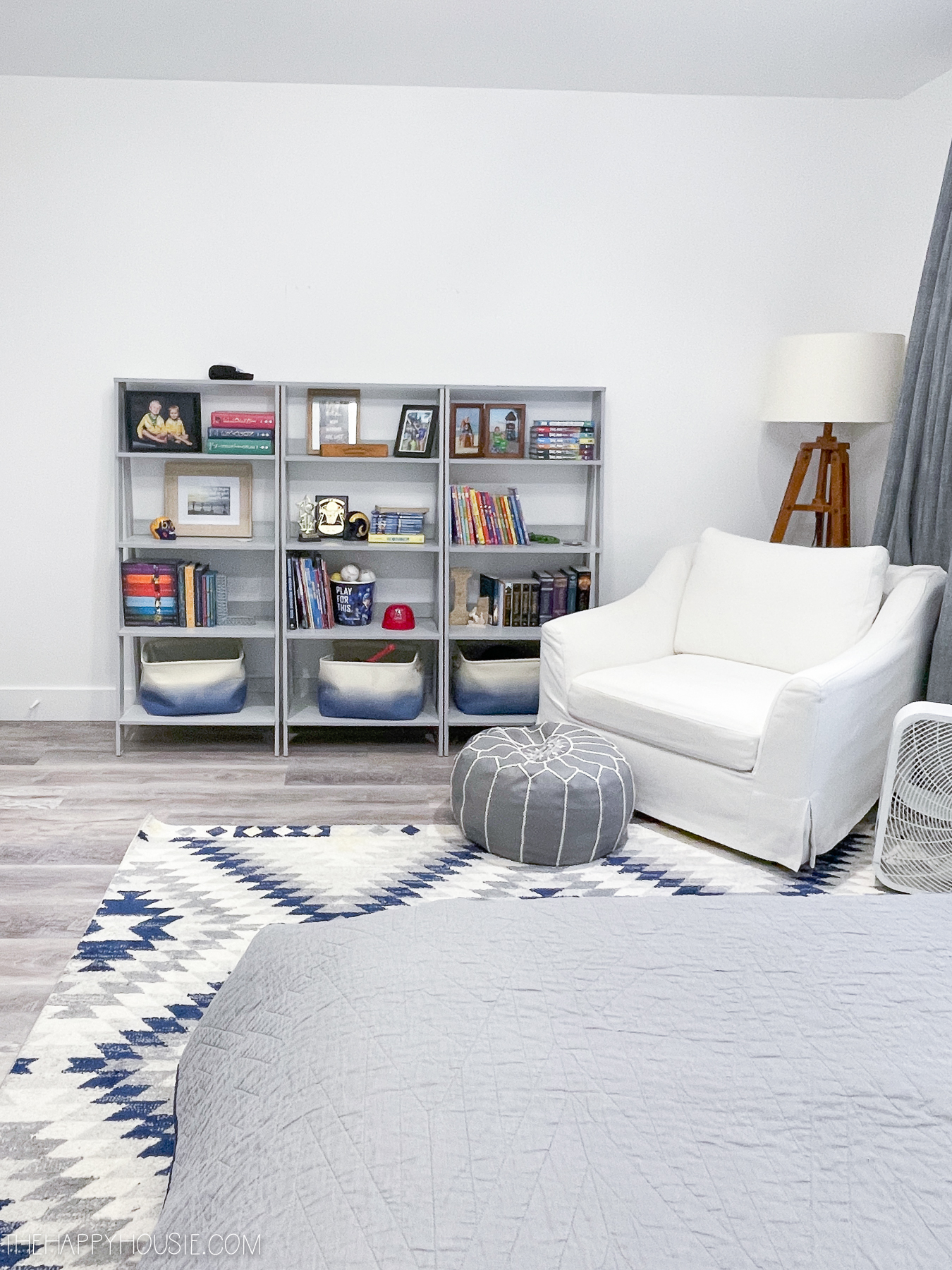 teen boy bedroom with ladder style bookcases and large white chair