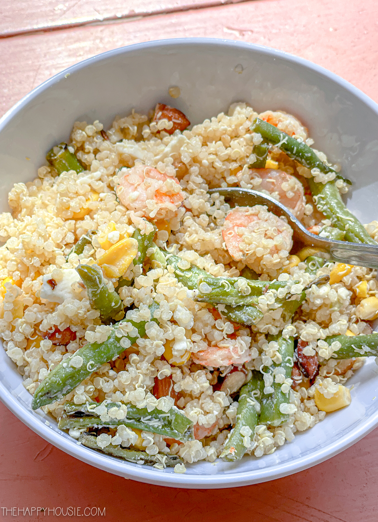 A bowl full of shrimp and quinoa salad.